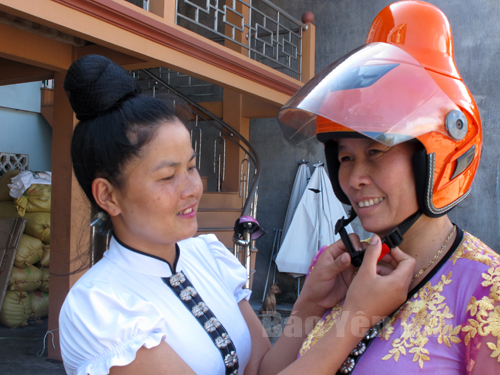Phụ nữ Thái ở thị xã Nghĩa Lộ sử dụng chiếc mũ bảo hiểm vừa được trao tặng.

